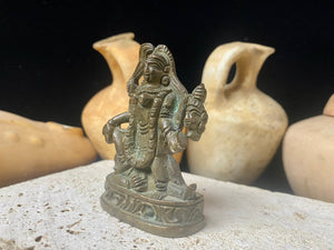 Kali with four arms, standing on Shiva, holding a curved sword, severed head and skull cup. Her fourth hand displays the gesture of blessing. She wears a garland of skulls around her neck and is covered by her long, wild, disheveled hair. This statue is approximately 80 years old (early 20th century). She has a fine and evenly dark patina. Measurements: height 7.3 cm, width 5 cm.