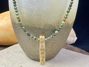 Tribal inspired necklace made from African jasper, highlighted with an antique Naga bone pendant and Kachin antique bone beads. Sterling silver findings and hook clasp. This unisex necklace is 45.5 cm (18") in length, pendant 5 cm (2") length.