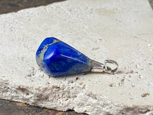 Freeform lapis lazuli top mounted pendant. The rich blue lapis originates from Afghanistan. Set in sterling silver with a generous bail to take a sizeable cord or chain. Height 5.5 cm