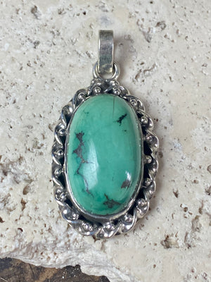 Arizona turquoise pendant set off by a detailed sterling silver bezel, with an enclosed silver back, topped by a large bail large. Measurements: 4.6 cm height including bail, width 2.2 cm