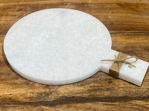 Our simple marble plate is designed for serving nibbles or for use as a cheeseboard. However, its simplicity means that it would also make a very nice plant or object stand. Hand carved in Rajasthan from white marble. A simple handle with hole for hanging completes the look. Measurements: length 29 cm, 21.5 cm disk diameter