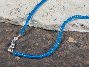 Short dark blue apatite necklace featuring graduated faceted apatite beads finished with a sterling silver lobster clasp. This is a lovely statement necklace that matches any skin tone or clothing. These stone are natural and not heat treated Measurements: 39.7 cm total length