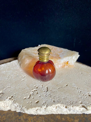 Small cranberry glass perfume bottles with hinged flip top brass lids. 