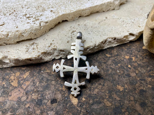 Mid 20th century Ethiopian silver crucifix. This may have been cut from a Marie Therese silver thaler, as the antique ones always are, however I believe that the style is more recent. Tests as silver. Plain on front side, plain back. Some wear at the head of the bail commensurate with its age. A wearable and collectable piece of jewellery. Measurements: length including bail 6 cm