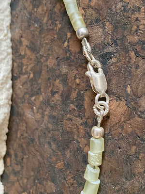 This unique choker features beautiful vintage beads from the Kashgar collection - blue green turquoise centre bead, Ethiopian opal, Bone beads from Burma, Pale green chrysoprase beads, Green serpentine tube beads from Afghanistan and 925 sterling silver detailing and lobster clasp. Length 40.5 cm