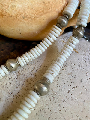 A mid-length white howlite and silver necklace crafted crafted from natural heshi cut beads, with a handmade sterling silver cross centrepiece and antique Indian silver beads. Finished with sterling silver ends and hook clasp. Total length 51.8 cm, pendant 2.5 cm diameter