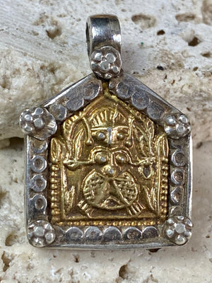 antique tribal amulet depicting Durga in Kali form. High grade silver with a 22 kt gold finish over the amulet face. Early 20th century or earlier. This is a unique amulet in its depiction of the goddess in tribal headdress and its use of silver and gold.  Height 2.7 cm including bail, width 2 cm