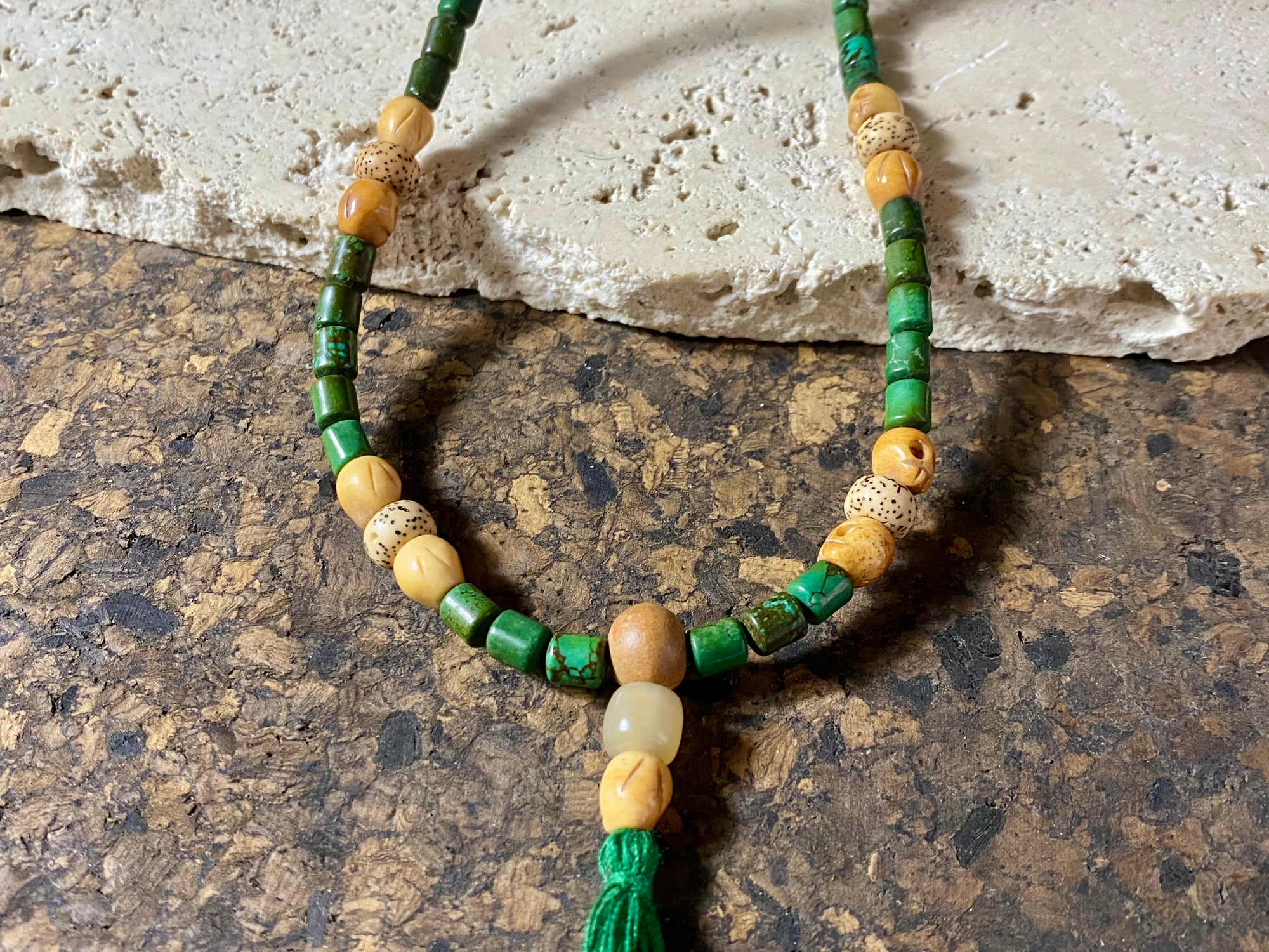 Our luxurious Buddhist mala contains 108 beads and has a beautifully organic look and feel. It's made from dark green turquoise beads, skull carved yak bone beads and lotus root beads, all finished with a sandalwood guru bead and a yak horn bead. Finished with a dark green tassel.