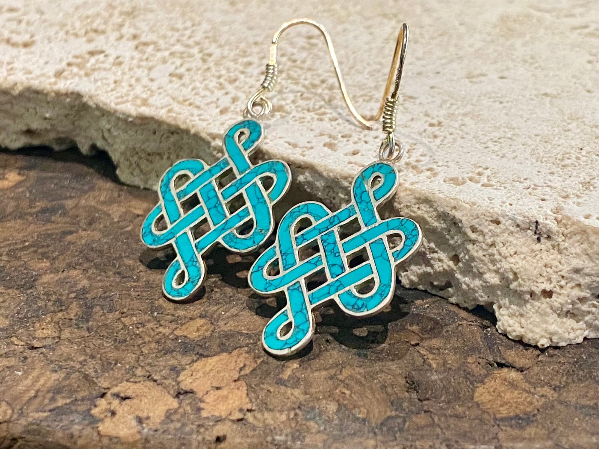 These sterling silver and turquoise earrings are the Buddhist symbol called the endless knot. They are finished with sterling silver hooks. Height 4.5 cm including hook.