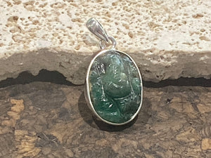 Hand carved from a single high quality translucent emerald and set in a silver surround with silver bail, this oval pendant features a beautifully detailed image of Ganesh.  Height including bail 3.1 cm, width 1.4 cm