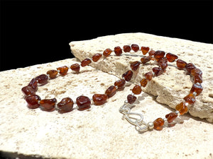 Cinnamon coloured, graduated hessonite garnet boulder beads, highlighted with sterling silver, finished with a silver hook clasp. Length 42 cm