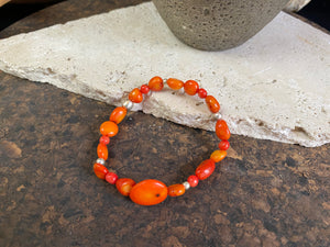 Charming bracelet made from Pacific deep sea bamboo coral in dark and light orange tones, finished with sterling silver. Elasticised cord for a seamless look.
