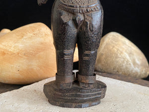 Carved hardwood Shiva Gangaur statue, southern Rajasthan, India. Rosewood. Late 19th century. The statue wears two metal bands as anklet decoration, tribal dress and some damage to his arms. Height 15.5 cm