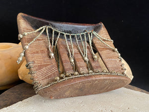 Kambatta wood headrest, Ethiopia. Early 1900's. Heavily carved and beaded. Dark patina and smooth wear on this piece are appropriate to its age. Measurements: height 16 cm (7"), width 18 cm