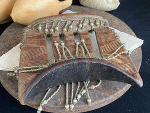 Kambatta wood headrest, Ethiopia. Early 1900's. Heavily carved and beaded. Dark patina and smooth wear on this piece are appropriate to its age. Measurements: height 16 cm (7"), width 18 cm