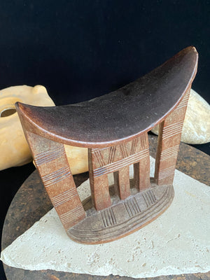 Old kambatta tribe wooden headrest from Ethiopia. Carved from a single piece of wood. Pre 1950. The patina and wear on this piece are appropriate to its age. In particular the upper surface is darkened from use. Measurements: height 18.5 cm