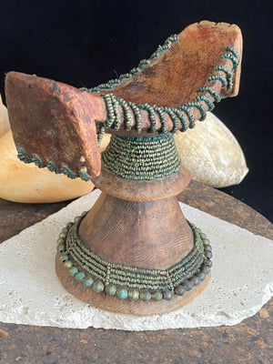 Very old Oromo wooden headrest from Ethiopia. Carved from a single piece of wood, heavily beaded with green oxidation. Pre 1950. The patina and wear on this piece are appropriate to its age.  Measurements: height 16 cm, width 18 cm