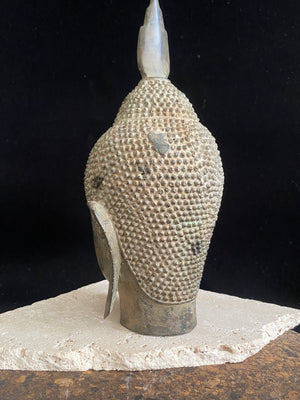 Thai Buddha head. Serene expression, hair topped with the flamed Ushnisha. Sukhothai style, bronze, mid 20th century. A softly contoured face with the bow shaped lips, prominent ears, arched eyebrows and aristocratic features typical of this style of work. Measurements: height 25 cm, width 11 cm