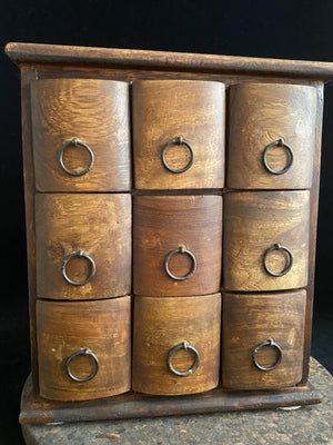 Simple curved face nine drawer cabinet trinket box. Made from solid Indian rosewood with iron rings as handles.  From Rajasthan, India. Made from Indian hard wood.  Height 28 cm, width 24.5 cm, depth 15.5 cm
