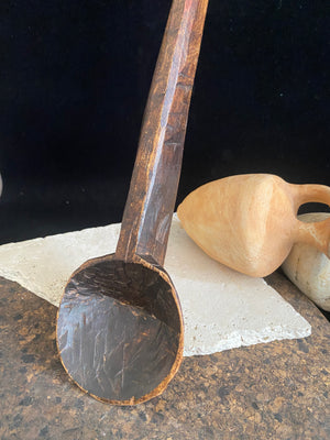 Vintage wood serving ladle. Hand carved wood. From northern India. This spoon is drilled and can be hung from its leather strap. This spoon has a lovely worn patina commensurate with its age. Each piece is hand carved, unique and artisan made. Length 58 cm, width of spoon 8 cm.