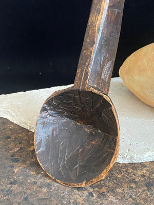 Vintage wood serving ladle. Hand carved wood. From northern India. This spoon is drilled and can be hung from its leather strap. This spoon has a lovely worn patina commensurate with its age. Each piece is hand carved, unique and artisan made. Length 58 cm, width of spoon 8 cm.