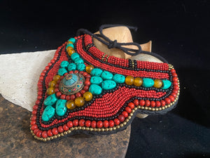 Traditional bib or pectoral beaded necklace, with a multitude of colourful ceramic and resin stones sewn onto a stiff fabric background and tied around the neck with a cord. Sikkim jewellery, India