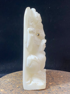 Hand carved marble stone statue of Ganesh. Our Ganesh sits on a lotus pedestal, while his mouse sits at his feet. One of his right hands is upraised in the gesture of protection, while the other holds his favourite ladoo sweet. Measurements: 22 cm high, 14 cm wide, 6 cm depth