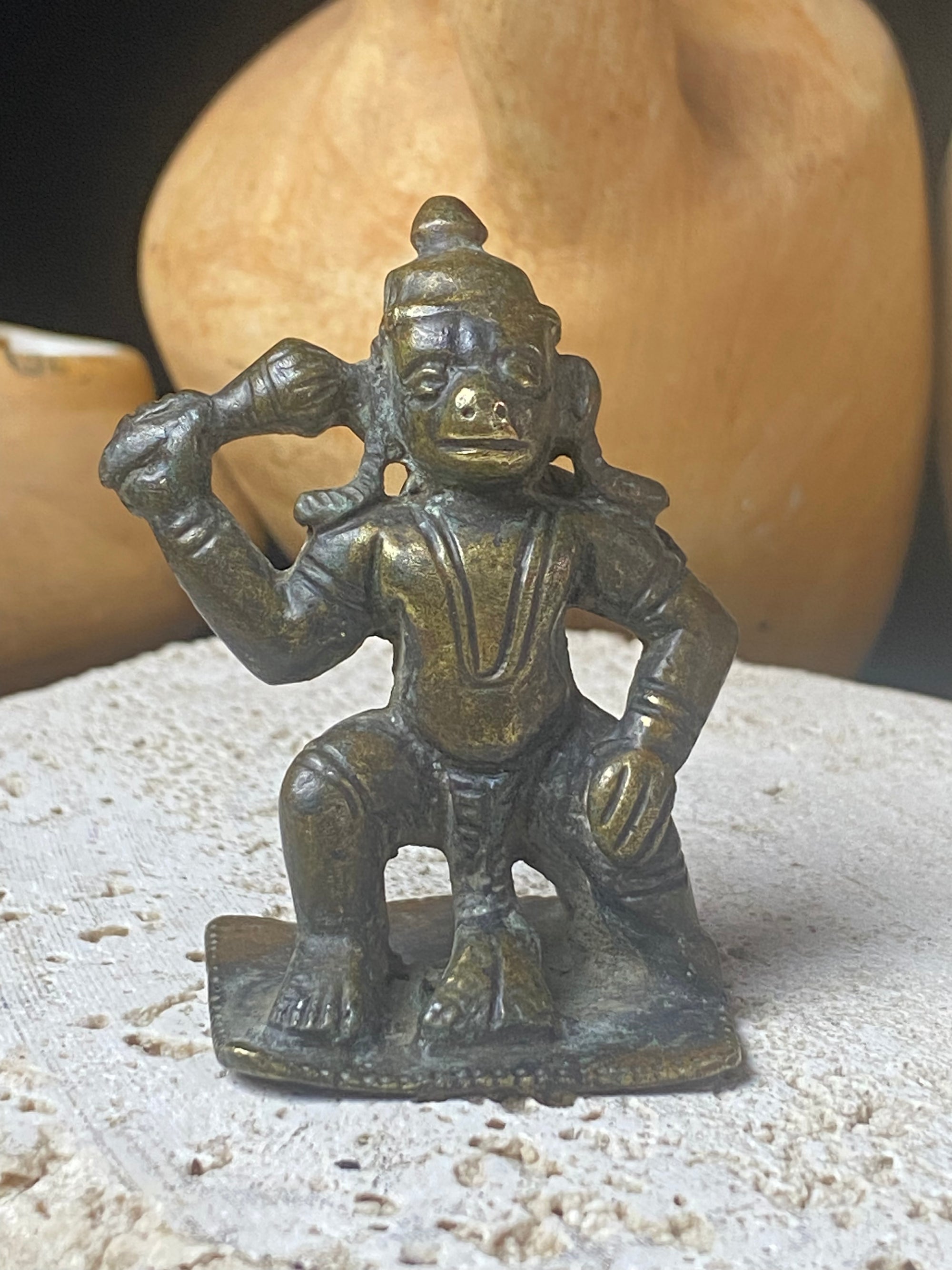 A small cast brass Hanuman in forward kneeling style. This piece has some rubbing on the face, shows a naturally darkened patina and is approximately 80 years old, although it may be older. Gujarat, India. Measurements: height 6 cm