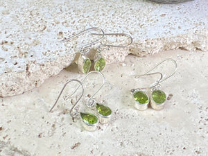 Beautiful peridot earrings featuring gem quality facet cut peridot stones in three shapes, teardrop, oval or leaf. A sterling silver mount and hook completes the look. These earrings are open at the back to allow light to shine through the stones. Around 3 cm length including hook