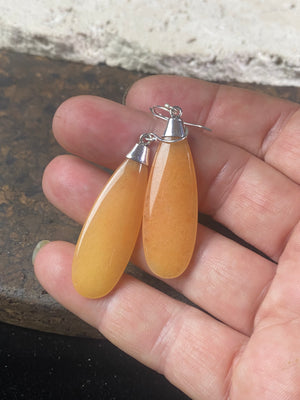 Translucent orange flat teardrop jade earrings set in stylish sterling silver mounts and hooks. Lightweight and easy to wear. 5 cm length including hook, width 1.2 cm at widest point 