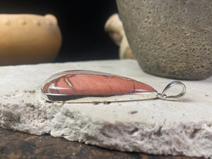 A unique pendant carved from a single piece of jasper intertwined with moonstone. A sterling silver bezel and generous bail completes this statement pendant. Open at the back to allow the stone to touch the skin. Measurements: height 6.8 cm including bail (2.75"), width 4 cm at widest point