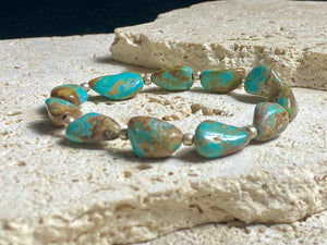 Natural Tibetan turquoise bracelet finished with sterling silver beads. Strong on sturdy elastic for a seamless look. Measurements: length 19 cm (7.5")