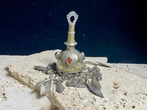 Tekke Turkoman women's cap jewellery.  High grade silver, 24k gold fire gilding, finished with four carnelian stones.All dangles are intact. Mid 20th Century. This would have once endowed the headdress of a Turkoman girl. Measurements: total height including dangles 18 cm (6.5"). Diameter at base 5 cm (1.5"). Height of body (without dangles) 8.5 cm