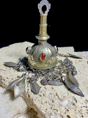 Tekke Turkoman women's cap jewellery.  High grade silver, 24k gold fire gilding, finished with four carnelian stones.All dangles are intact. Mid 20th Century. This would have once endowed the headdress of a Turkoman girl. Measurements: total height including dangles 18 cm (6.5"). Diameter at base 5 cm (1.5"). Height of body (without dangles) 8.5 cm