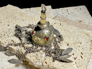 Tekke Turkoman women's cap jewellery.  High grade silver, 24k gold fire gilding, finished with four carnelian stones.All dangles are intact. Mid 20th Century. This would have once endowed the headdress of a Turkoman girl. Measurements: total height including dangles 18 cm (6.5"). Diameter at base 5 cm (1.5"). Height of body (without dangles) 8.5 cm