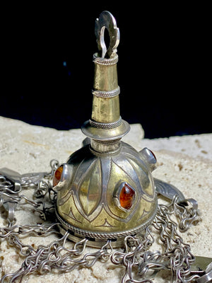 Tekke Turkoman women's cap jewellery.  High grade silver, 24k gold fire gilding, finished with four carnelian stones.All dangles are intact. Mid 20th Century. This would have once endowed the headdress of a Turkoman girl. Measurements: total height including dangles 18 cm (6.5"). Diameter at base 5 cm (1.5"). Height of body (without dangles) 8.5 cm
