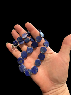 Natural lapis lazuli flat disk beads, colour matched and graduated, with sterling silver spacer beads and a sterling silver clasp. Length 43 cm