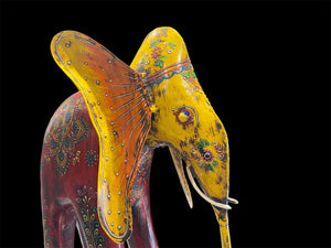 Our biggest and brightest elephant statue. Hand carved from solid hard wood with a recycled iron trunk, ears, tusks and trunk, full of gorgeous character and painted in intricate embossed detail.  Measurements: height 48.5 cm, length 32 cm, depth 12 cm