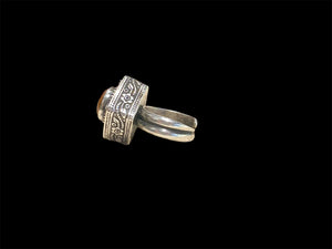 An unusual ring featuring a round carnelian stone set in a high box setting. Afghanistan, mid to late 20th century. Can be worn by either men or women. Measurements: Ring face 2.5 x 2.5, cm, height 1.5 cm. This is an adjustable ring spanning sizes 7 - 8