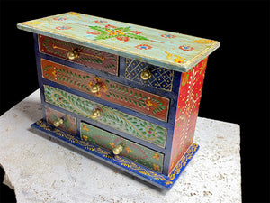 Hand painted chest of drawers features six drawers of varying sizes. Petite feet and polished brass knobs as handles. Small and compact, it is an ideal choice for storing a variety of items. Width 24 cm, depth 10 cm, height 17.5 cm