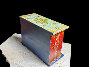 Hand painted chest of drawers features six drawers of varying sizes. Petite feet and polished brass knobs as handles. Small and compact, it is an ideal choice for storing a variety of items. Width 24 cm, depth 10 cm, height 17.5 cm