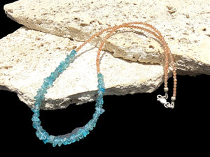 Sparkling facet cut sunstone is teamed with aqua blue fluorite to create a unique necklace. Silver bead detailing and a silver lobster clasp, 44 cm length.