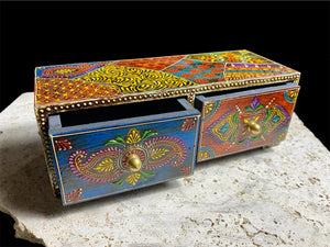 This intricately painted box features two spacious drawers, small feet and brass knobs as handles. The roominess of the drawers means our long, low chest is perfect for holding everything from trinkets to jewellery and keys. A lovely, hand painted piece of craftsmanship from Rajasthan, India.
Measurements: width 24, depth 9 cm, height 9 cm