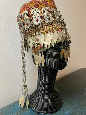 Ersari headdress consisting of a metal gaashbaagh & a high embroidered conical hat into which it attached with long spikes. The cap is quilted cotton covered in velvet and detailed silk embroidery. An heirloom piece, dating from 1870-1890. Cap height 23 cm. Tiara: width 53 cm, height of band 7 cm, side dangles 44 cm