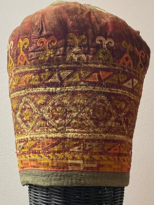 Ersari headdress consisting of a metal gaashbaagh & a high embroidered conical hat into which it attached with long spikes. The cap is quilted cotton covered in velvet and detailed silk embroidery. An heirloom piece, dating from 1870-1890. Cap height 23 cm. Tiara: width 53 cm, height of band 7 cm, side dangles 44 cm