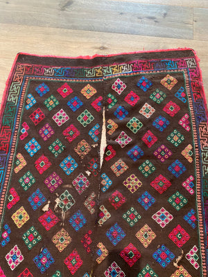 Yathra weaving, from the Chumey Valley in Bumthang, Bhutan. Hand spun and natural dyed yarn is backstrap woven into wool panels, then embroidered with wool thread. Mid 20th century. This textile is called a denkeb and was likely used as a rain cloak. Its condition is commensurate with its age. Measurements: 173 x 84 cm