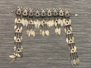 Ersari headdress consisting of a metal gaashbaagh & a high embroidered conical hat into which it attached with long spikes. The cap is quilted cotton covered in velvet and detailed silk embroidery. An heirloom piece, dating from 1870-1890. Cap height 23 cm. Tiara: width 53 cm, height of band 7 cm, side dangles 44 cm