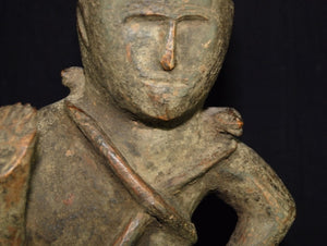 Naga antique tribal statue, an ancestor figure with right hand raised in protection, head adorned with plumed cap. Two snakes are wrapped around the torso, their heads resting on the shoulders, dressed in a fringed kirtle. 19th C or earlier, well preserved with an aged patina. Height 56 cm, width 16.5 cm, depth 15 cm