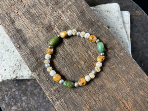 Stretchy bracelet featuring hand carved yak bone skulls, natural antique Tibetan turquoise, undyed howlite , carved lotus root and sterling silver beads. Designed to fit on a wrist 11-14 cm circumference