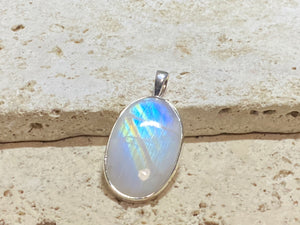Large oval rainbow moonstone pendant set in sterling silver with a generous bail to take a large chain or cord. A beautiful stone with light blue, green and orange colour. 